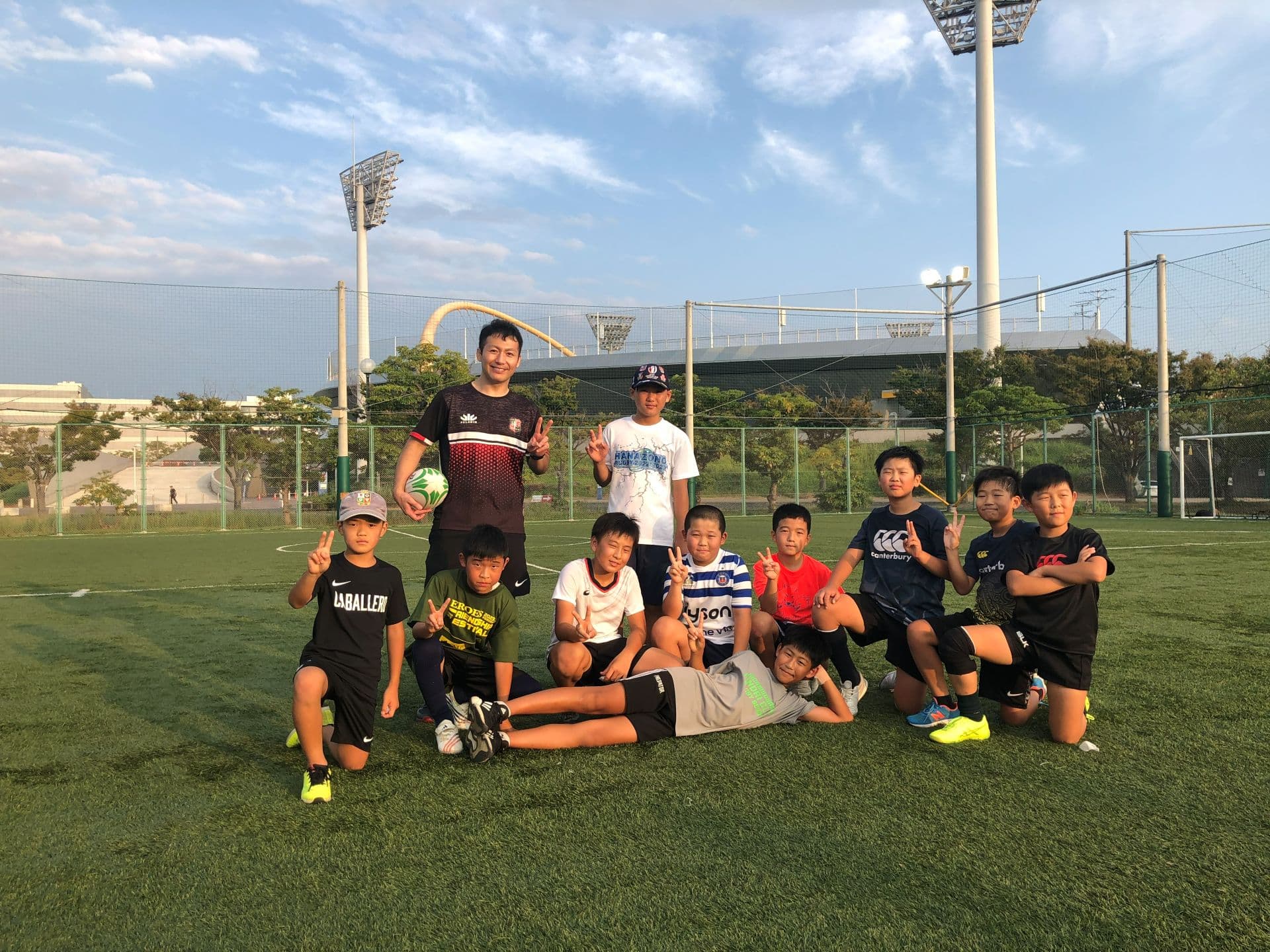 ラグビーボールを持つコーチと小・中学生の選手たち