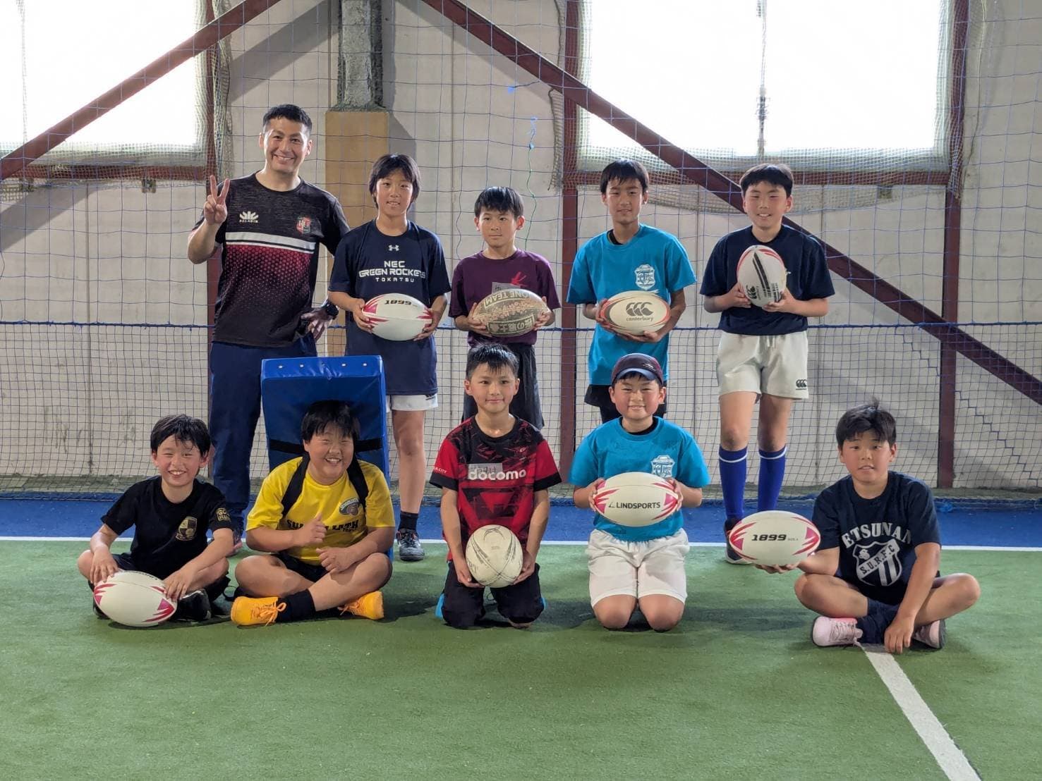 ラグビーボールを持って笑顔で並ぶ小学生の選手たち